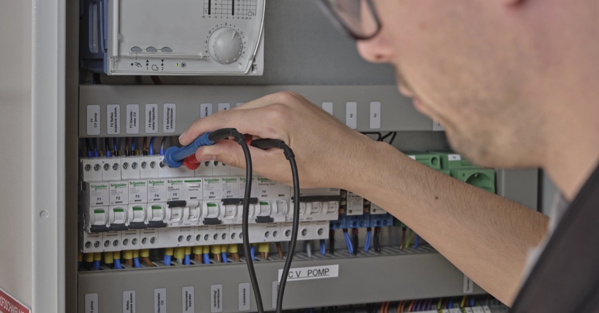 Monteur controleert met meetapparatuur de componenten in een elektrische schakelkast.