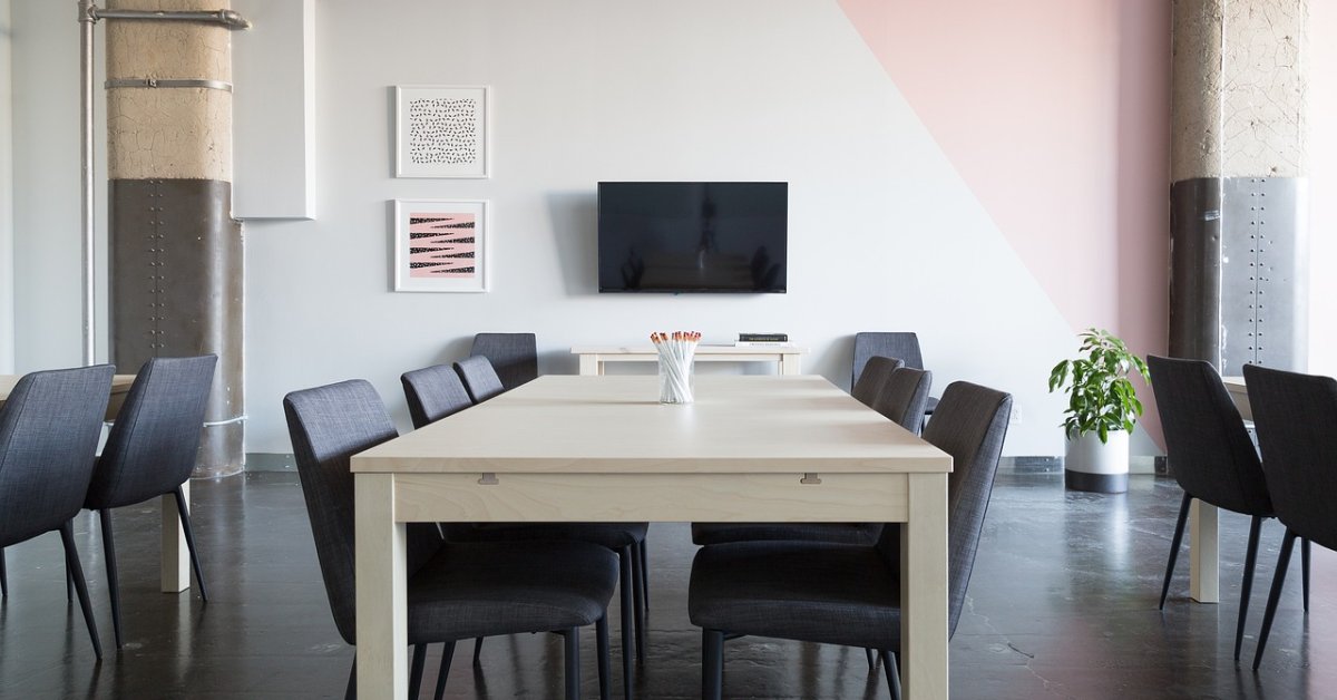 Opgeruimde vergaderruimte met een lange tafel en stoelen